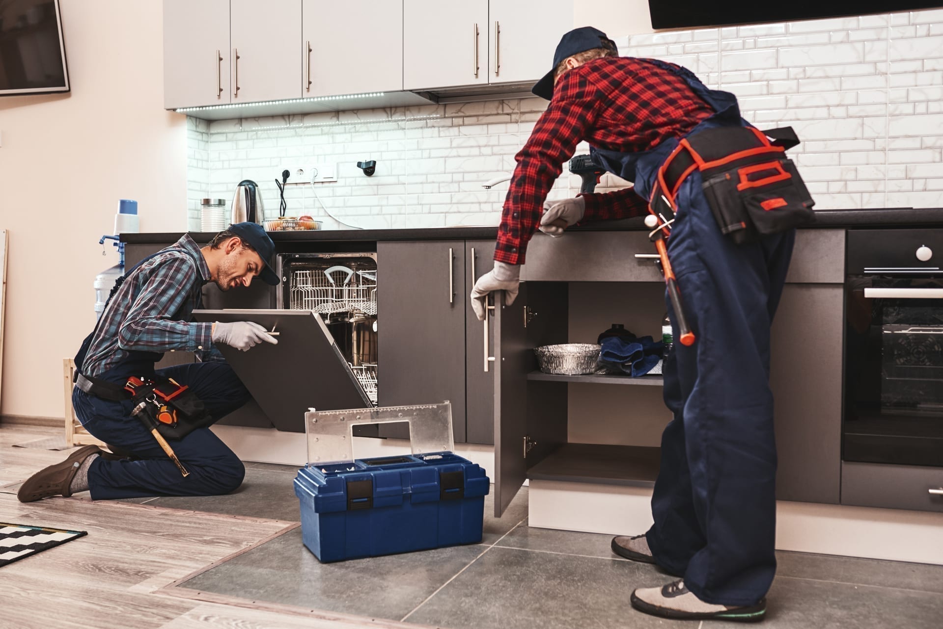 Appliance repair technician with tablet looking up model and parts at customer home
