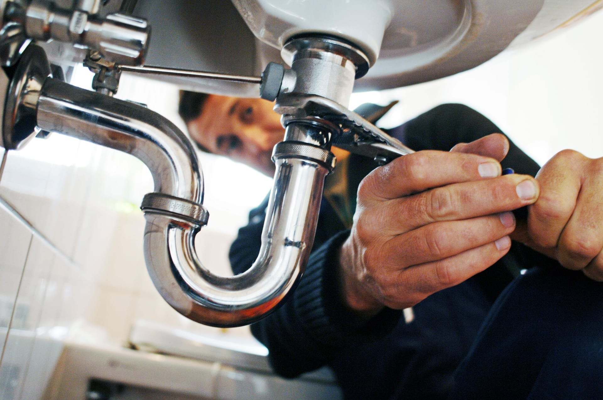 Plumber using mobile device to complete work order and document repair