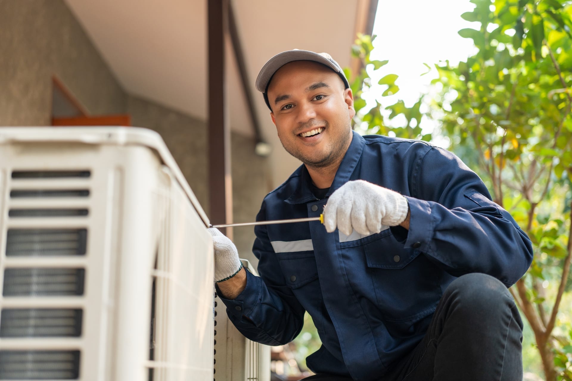 HVAC technician at job site with tablet for scheduling and work orders